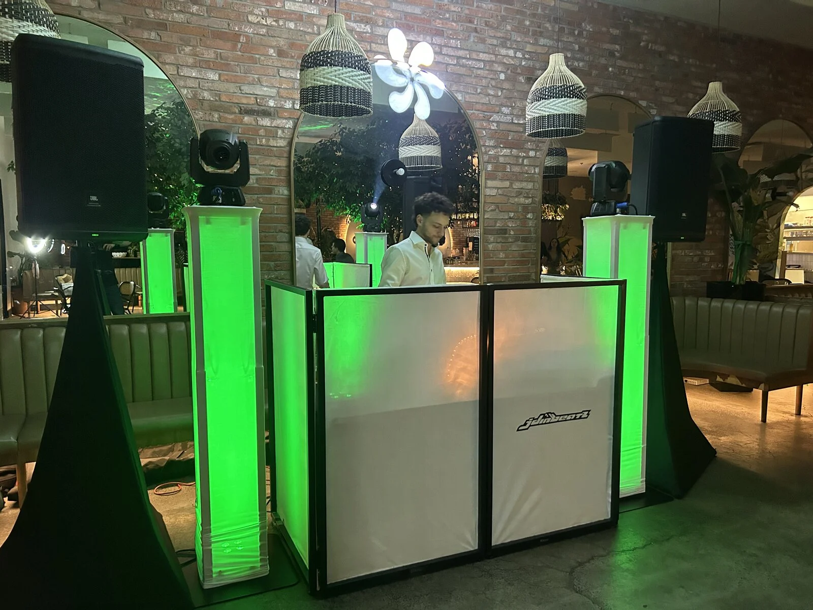 JDiN Beatz branded DJ booth with green uplighting at a Montreal venue